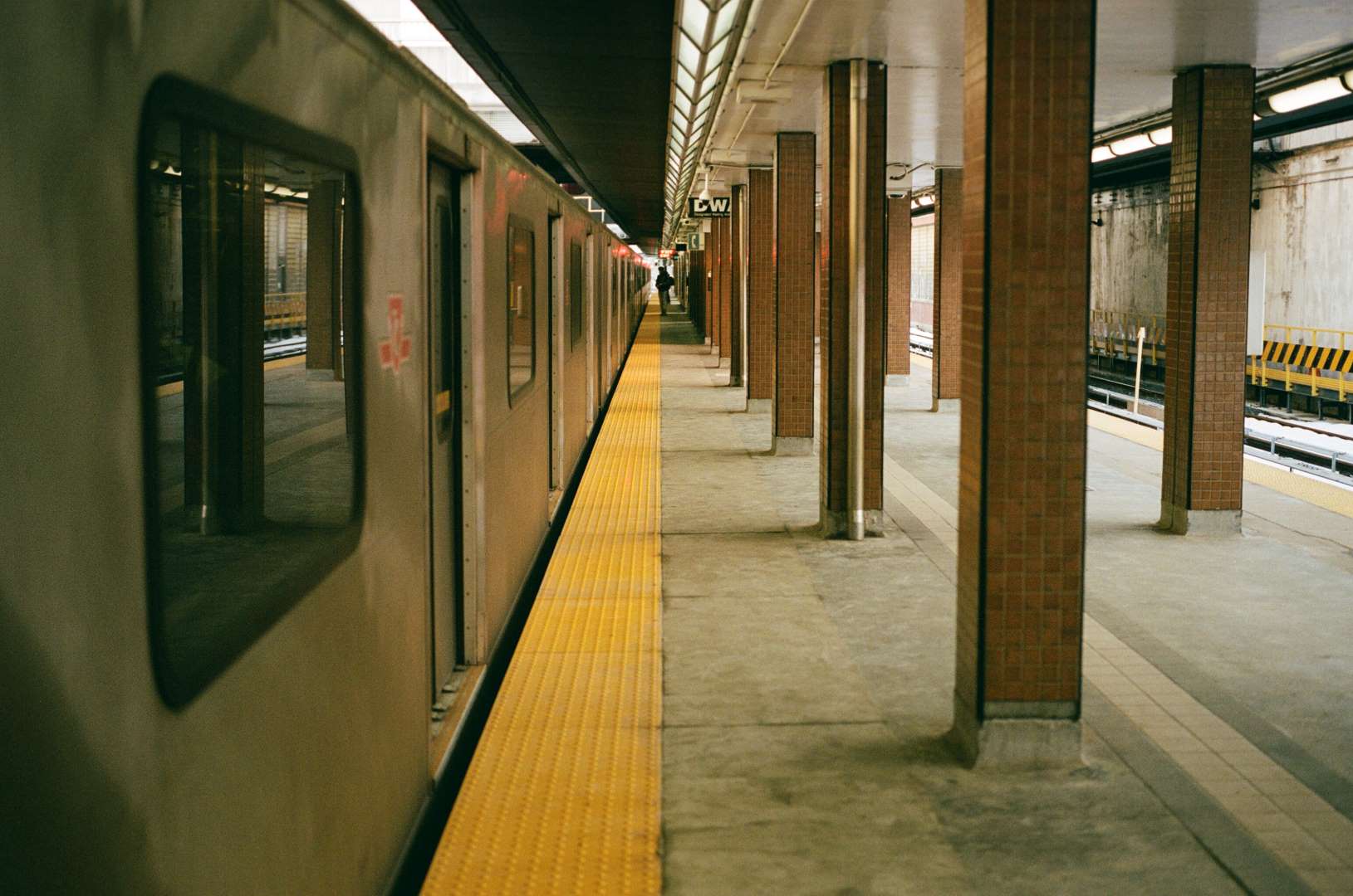 A colour photograph of a subway platform as the train pulls away