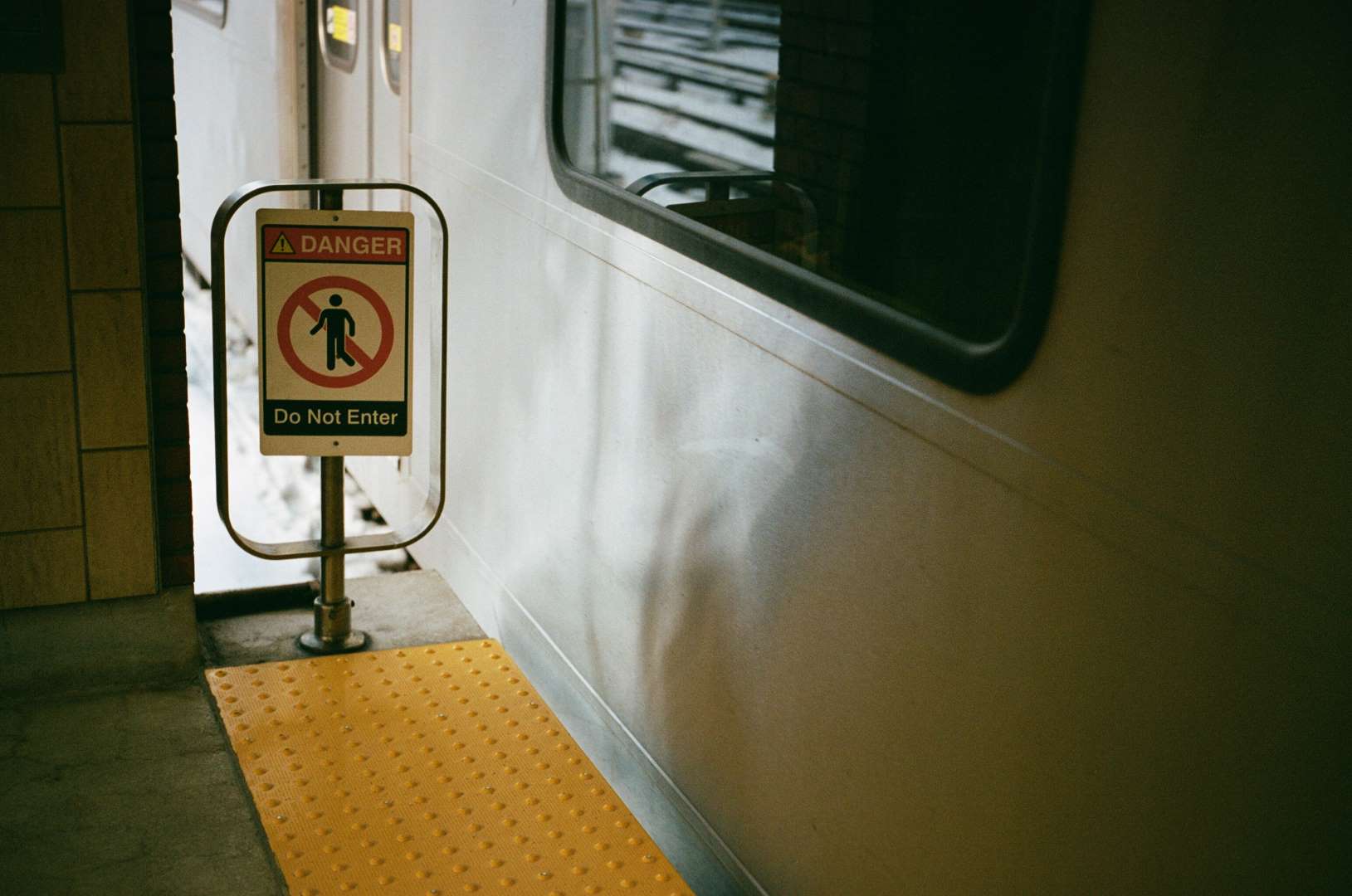 A colour photograph of a small barrier on a subway platform with a sign that reads 'Do Not Enter'