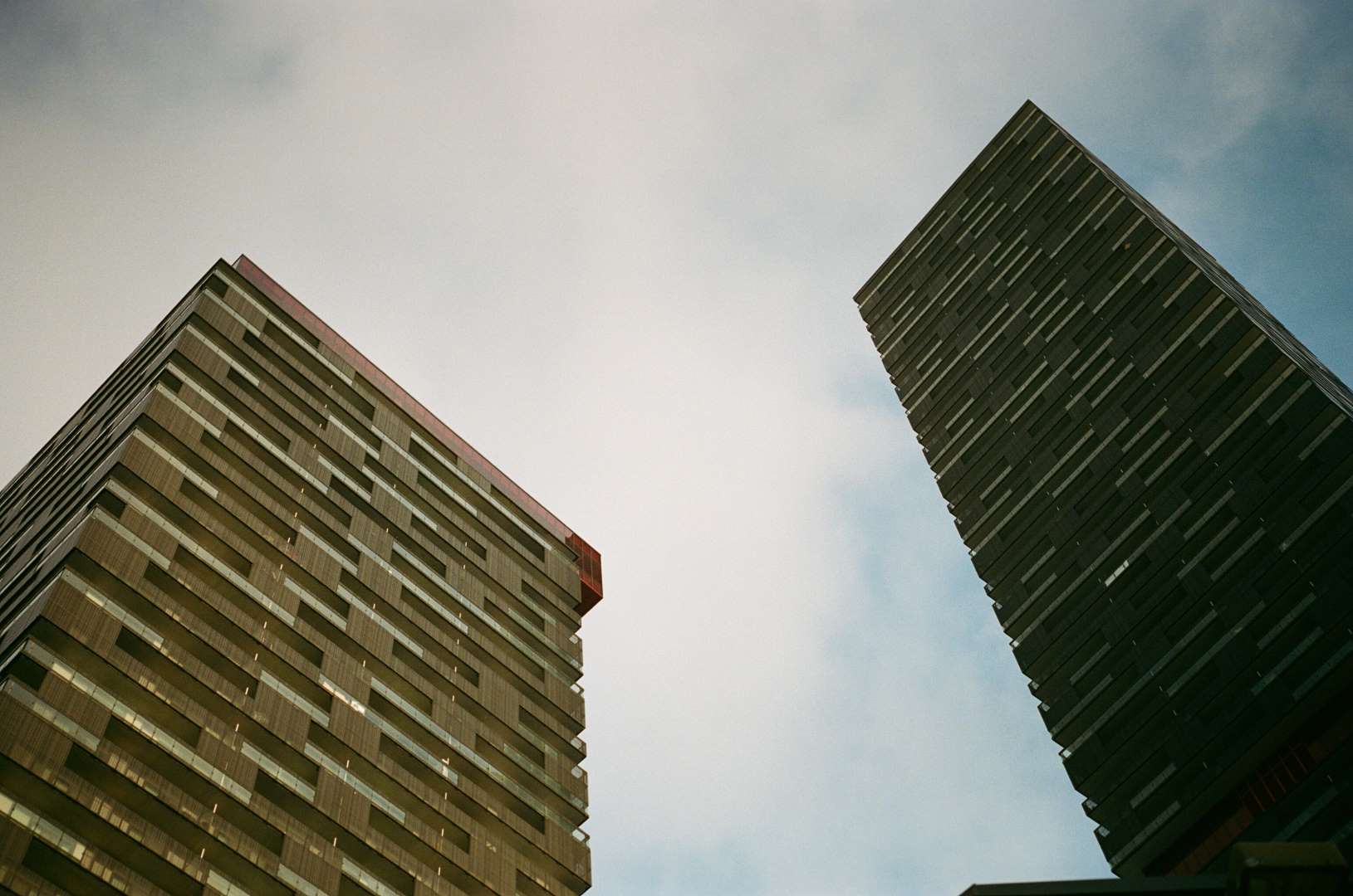 A colour photograph of two buildings in the setting sun