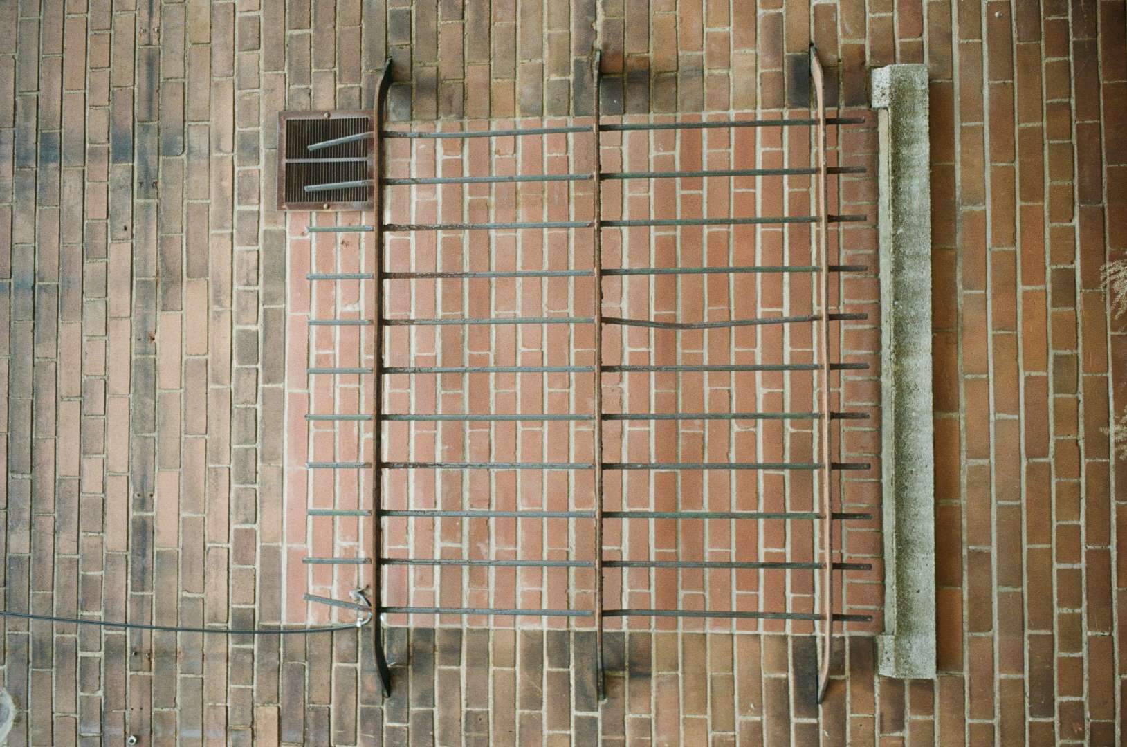 A colour photograph of a bricked up window, the security bars still in place