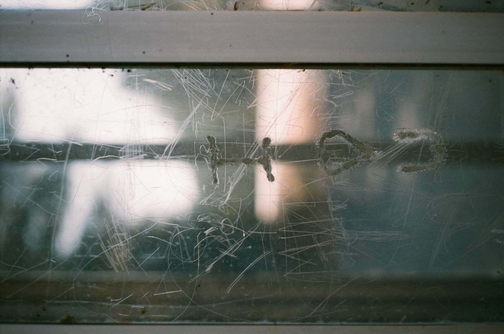 A colour photograph of a phone booth on an empty rural road with I ♥ U burned into the plexiglass